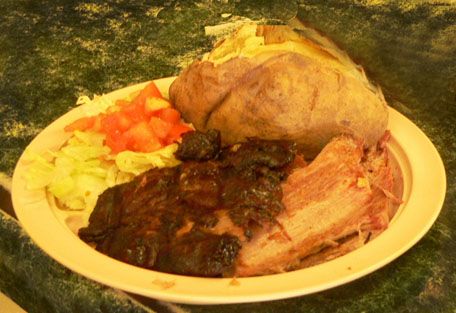 Bar-B-Que plate with sliced pork, baked potato and salad